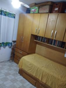 - une chambre avec un lit et des placards en bois dans l'établissement Residence Lisboa, à Itanhaém