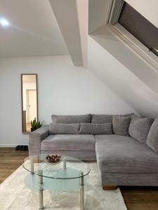 un soggiorno con un divano e un tavolo di vetro di Nature Retreat Ober-Mörlen a Ober-Mörlen