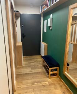 een hal met een zwarte deur en een houten vloer bij Apartament Dębowy Stół in Rzeszów +3 foto's