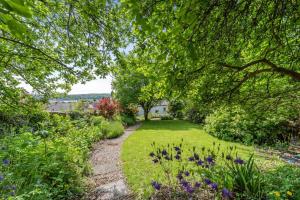 3 Bed in Llansteffan oc-78278 في Llanstephan: طريق من خلال حديقة بها زهور وأشجار