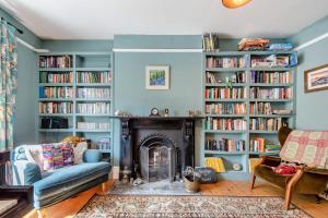 3 Bed in Llansteffan oc-78278 في Llanstephan: غرفة معيشة مع موقد و احجز رفوف مليئة بالكتب