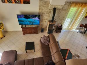 un salon avec un canapé et une télévision à écran plat dans l'établissement Monis ruhiges Ferienhaus, à Ménétreuil