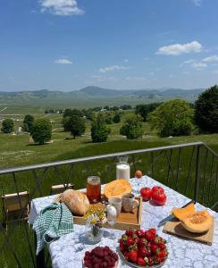 a table with food and vegetables on a balcony at Monte zone Zabljak in Žabljak
