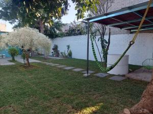 a garden with white flowering trees and a swing at In Oaxaca Casa RodSa in San Agustin de las Juntas