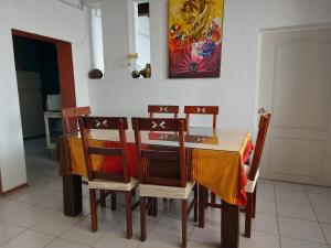 a dining room table with chairs and a painting on the wall at In Oaxaca Casa RodSa in San Agustin de las Juntas