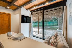 a living room with a couch and a large window at 5 Lofts En La Paraiso in Playa Grande