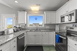 Ocean Views & Coastal Charm at ForeShore OKI في أوك آيلاند: مطبخ بخزائن بيضاء ومغسلة