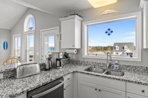 Ocean Views & Coastal Charm at ForeShore OKI في أوك آيلاند: مطبخ مع حوض ونافذة