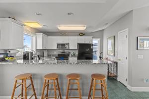 Ocean Views & Coastal Charm at ForeShore OKI في أوك آيلاند: مطبخ مع خزائن بيضاء وكراسي البار +47 صورة