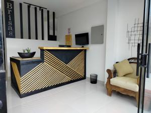 Una habitación con un mostrador con una silla y un televisor. en Brisas Hotel, en Toro Toro