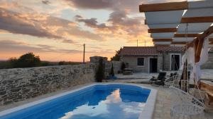 een villa met een zwembad en een stenen muur bij Juniper Stone Cottage by Villas Guide in Alavanja