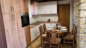 een keuken met een tafel en stoelen en een keuken met witte kasten bij Juniper Stone Cottage by Villas Guide in Alavanja