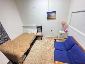 Four Star Royel Real Estate في أبوظبي: غرفة نوم صغيرة بها سرير وكرسي