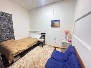 Four Star Royel Real Estate في أبوظبي: غرفة نوم صغيرة بها سرير وكرسي