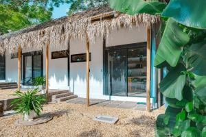 a building with a thatched roof and glass doors at 5 Lofts En La Paraiso in Playa Grande