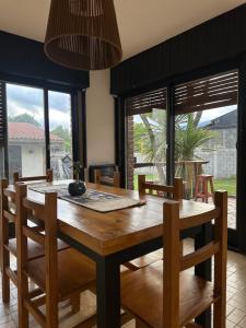 a dining room with a wooden table and chairs at Travesia Sur Hostel in El Bolsón +76 photos