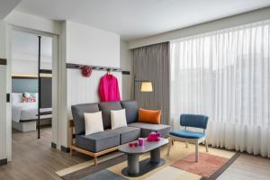 a living room with a couch and a chair at Moxy Kathmandu in Kathmandu