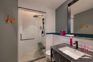 a bathroom with a shower and a sink and a toilet at Moxy Kathmandu in Kathmandu +10 photos