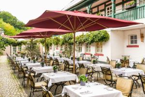 a row of tables and chairs with umbrellas at Bollants SPA im Park, Autograph Collection in Bad Sobernheim
