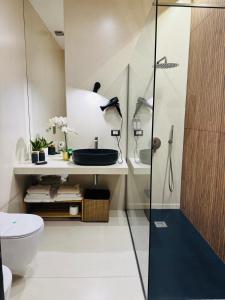 un bagno con lavandino e doccia in vetro di Aledo Boutique Apartments a Napoli