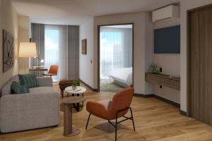 a living room with a couch and a bed at Courtyard by Marriott Guadalajara Andares in Zapopan