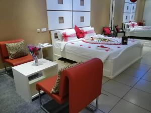 MandanouMiliet HOTEL的一间卧室,有一张大床和一把红椅子