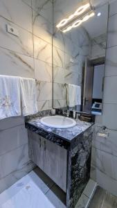 MandanouMiliet HOTEL的大理石浴室配有水槽和镜子