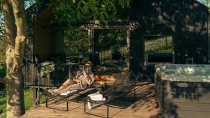 Un uomo seduto sulle sedie accanto al fuoco di RELAX HILL Vendégház a Dunabogdány