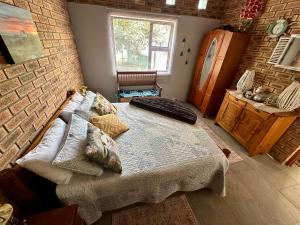 a bedroom with a bed and a brick wall at Prag Overnight Room in Orania