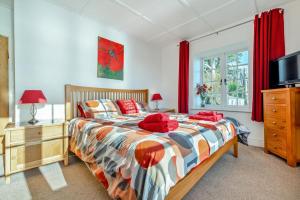 a bedroom with a bed with red pillows on it at 3 Bed in Polperro oc-h34100 in Polperro