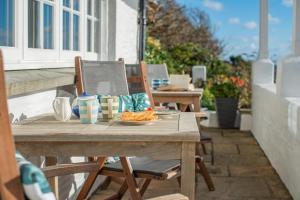 a wooden table with a plate of food on a patio at 3 Bed in Polperro oc-h34100 in Polperro