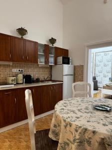 een keuken met een tafel en een witte koelkast bij Forst Apartman in Eger