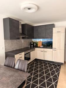 a kitchen with white cabinets and a black floor at Wohnung in Hüttau in Sonnberg