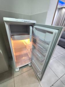 un frigorifero vuoto con la porta aperta in una cucina di Apartamento Moderno e Confortável a Lavras
