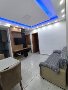 un soggiorno con letto e TV sul soffitto di Apartamento Moderno e Confortável a Lavras