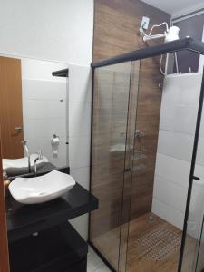 un bagno con lavandino e doccia in vetro di Apartamento Moderno e Confortável a Lavras Altre 13 foto