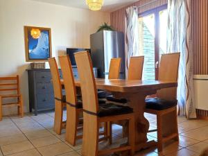 een eettafel met stoelen en een koelkast bij Chalet Mitoyen 7p avec Piscine, Sauna, Parking Gratuit et Proche Commerces - FR-1-863-8 in Le Dévoluy