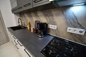 a kitchen with a stove and a counter top at FLH - Moonwalk in Sibiu +34 photos