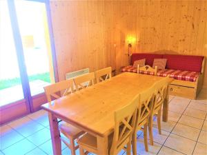 een houten tafel en stoelen in een kamer met een bank bij Chalet Mitoyen 3 Pièces 7 Pers. avec Piscine et Sauna - Résidence Les Flocons du Soleil - FR-1-863-13 in Le Dévoluy