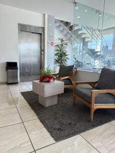 un vestíbulo con 2 sillas y una mesa en un edificio en ZAMORA EJECUTIVO EXPRESS, en Zamora de Hidalgo