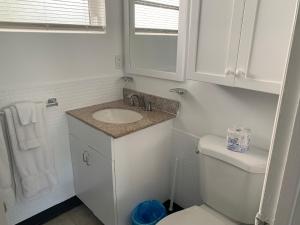 OCEANS 735 of DEERFIELD BEACH في ديرفيلد بيتش: حمام أبيض مع حوض ومرحاض