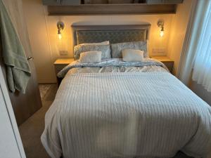 a bedroom with a large bed with two pillows at Home from Home at the Hendersons Caravan in Kilwinning