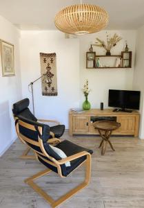 a living room with a rocking chair and a television at L'insouciance, a cottage in Provence in La Celle-sous-Gouzon