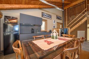 Maison Clavon في Verrayes: مطبخ مع طاولة خشبية وثلاجة