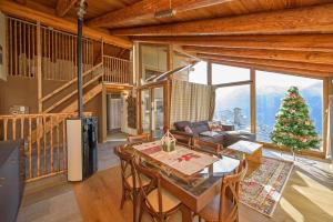 Maison Clavon في Verrayes: غرفة معيشة مع طاولة وشجرة عيد الميلاد