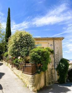 a house with a fence and trees on a street at L'insouciance, a cottage in Provence in La Celle-sous-Gouzon