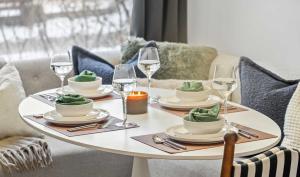 ドラムヘラーにあるFossil Flats 3BR Designer Home in Centre of Townの白いテーブル(ワイングラスと皿付)