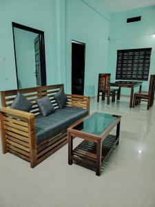 a living room with a couch and a coffee table at JANATHA home stay in Varkala