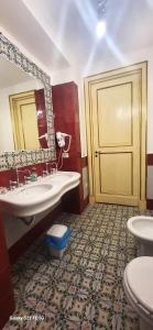 een badkamer met 2 wastafels, een spiegel en een deur bij Art house Venusio luxury home in Napels