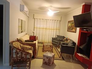 een woonkamer met banken en een flatscreen-tv bij Apartamento Capão Novo in Capão da Canoa +72 foto's